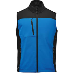 A softshell vest in blue and black, featuring zippered pockets and a high collar, with a logo on the front.