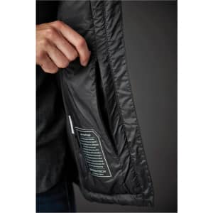 A black women's jacket with a pocket being opened, featuring a tag visible inside.