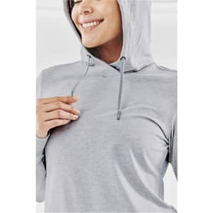 A grey women's Montebello pullover hoody with a hood and drawstrings, worn by a smiling model.