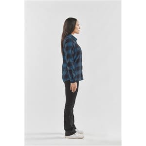 A side view of a woman wearing a blue and black checkered button-up shirt with black jeans and white shoes.