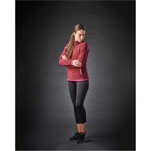 A female model wearing a maroon women's fleece 1/4 zip jumper paired with black leggings and athletic shoes.