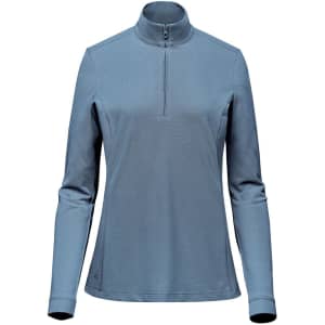 A women's 1/4 zip pullover in a soft blue colour, featuring long sleeves and a stand-up collar. It has a logo.
