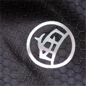 A close-up of a textured fabric in black with a circular logo pattern.