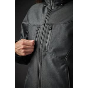 A close-up of a dark grey women's jacket featuring zippered pockets and a high collar, with a person adjusting the zipper.