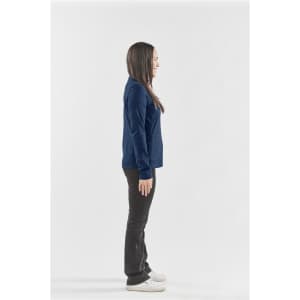 A navy women's performance jacket is displayed on a model standing sideways, paired with black trousers and white shoes.