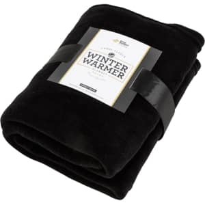 A black Coral Fleece blanket wrapped with a band featuring branding, showcasing its soft texture and warmth.