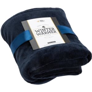 A navy blue coral fleece blanket, neatly rolled and tied with a ribbon, featuring a branding tag.
