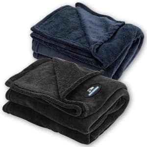 A folded coral fleece blanket in navy blue and a second in charcoal grey, both with a logo.