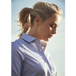 A women's button-up shirt in navy blue and white check pattern, with a collar, being worn by a model outdoors.