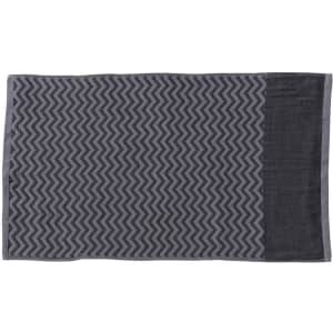 A grey gym towel featuring a textured zigzag pattern and a convenient pocket. It has a logo in one corner.