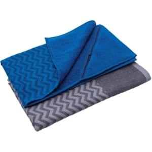 A blue gym towel with a pocket, layered over a grey and patterned towel. The design features a chevron pattern.