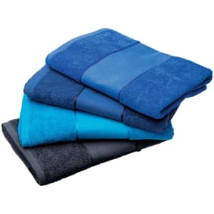 A set of four beach towels in varying shades of blue, stacked neatly. One towel is dark navy, another is light blue, and the third is teal.