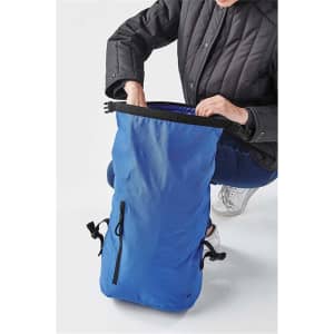 A blue roll-top backpack displayed with a person opening the top, featuring adjustable straps and a zippered pocket.
