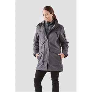 A woman wearing a grey 5-in-1 system jacket with pockets and a zip front, featuring a logo.