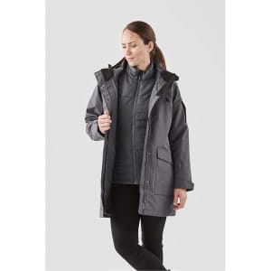 A grey women's 5-in-1 system jacket featuring a hood and multiple pockets, modelled by a woman.