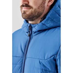 A blue quilted hoody featuring a high collar and a zippered front, with a logo on the chest.
