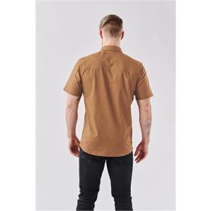 A short-sleeved, button-up shirt in tan with a patterned design, featuring a collar and a logo on the back.
