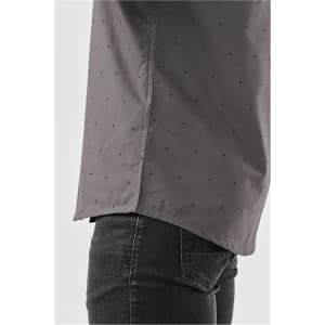 A grey button-up shirt with a subtle pattern, featuring side slits and a modern cut. It has a logo on the label.