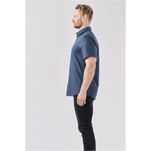 A men's short-sleeve button-up shirt in navy blue with a subtle pattern, featuring a logo on the front.