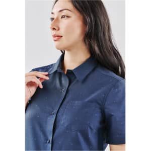A blue button-up women's shirt with short sleeves and a small pocket, featuring a subtle pattern.