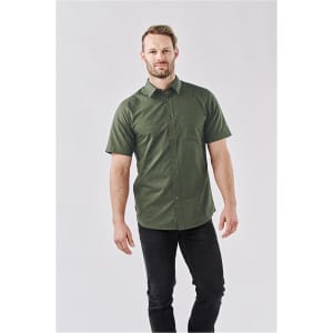 A short-sleeved, green button-up shirt with a subtle pattern, complemented by a model wearing dark jeans.