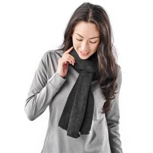 A woman wearing a dark grey scarf, featuring a soft knit texture, paired with a light grey top.