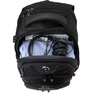 A black backpack with a zippered compartment containing a shirt, headphones, and cables. It features a logo.