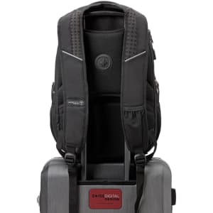 A black Swissdigital Stealth Neptune Backpack with padded straps and a logo, resting on top of a grey suitcase.