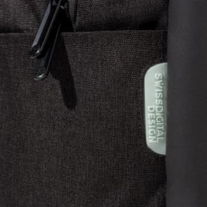 A close-up of a black backpack featuring a textured fabric and a logo patch.