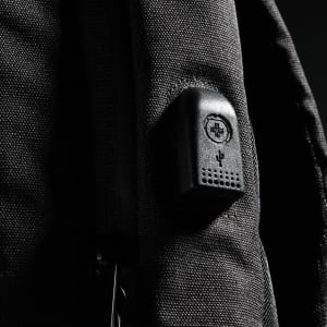 A black backpack with a textured surface and a small logo integrated into the design.