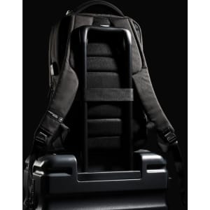 A black Swissdigital Arosa Backpack rests on a suitcase, featuring straps and a sleek design.