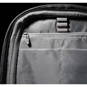 A grey backpack interior features zippered and compartmental storage with ergonomic design elements.