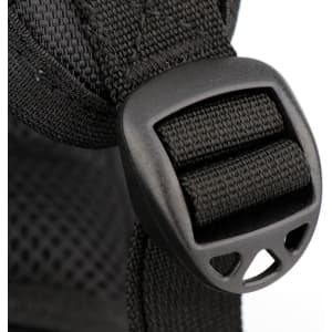 A close-up of a black backpack strap featuring a plastic buckle detail.