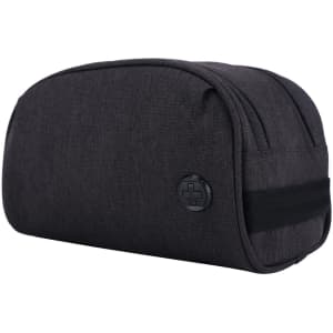 A dark grey toiletry bag with a logo, featuring a rounded shape and a black strap.