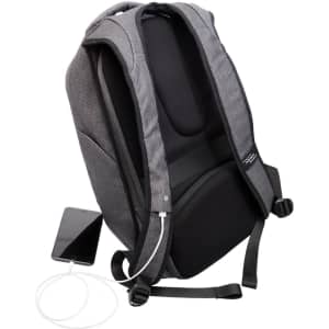 A grey anti-theft backpack with adjustable straps, featuring a charging port and a smartphone beside it.