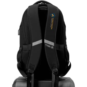 A black Swissdigital Vector Backpack featuring padded straps and a logo, resting on a suitcase.