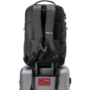 A black Swissdigital Java Backpack rests on a silver suitcase, featuring padded straps and a logo.