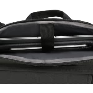 A black backpack interior featuring a sleek laptop compartment and grey lining. It includes a brand logo.