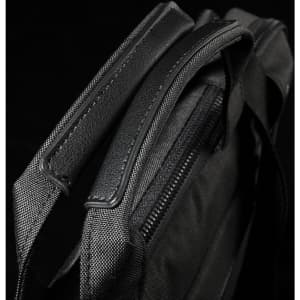 A black laptop sleeve with textured fabric and zipped closure, featuring sturdy handles for carrying.