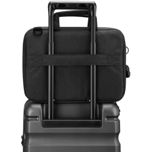 A black laptop sleeve with a handle, positioned on top of a suitcase, showcasing its sleek design.