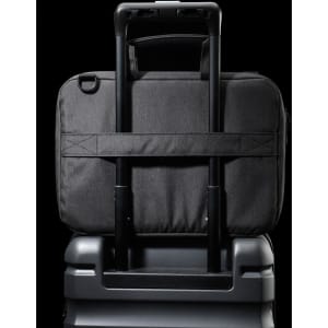 A black laptop sleeve with a handle, designed to fit securely on a suitcase's extendable handle.
