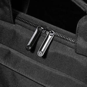A black laptop sleeve with dual zippers, featuring a sleek and textured fabric design.