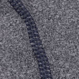 A close-up of a textured grey fabric with a contrasting navy seam, featuring a logo.