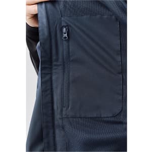 A close-up of a navy lightweight rain jacket featuring a zipped pocket and mesh detailing. It includes a logo.