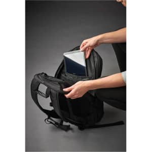 A black laptop bag with a person placing a laptop into a padded compartment. The bag features a logo.