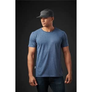 A men's crew neck T-shirt in blue, paired with a black cap, displayed on a model against a dark background.