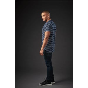 A man wearing a navy and white striped crew neck t-shirt, paired with dark jeans and black sneakers.