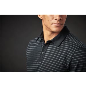 A close-up of a men's black and grey striped polo shirt featuring a collared neck and buttons. The shirt has a label.