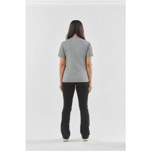 A woman stands with her back to the camera, wearing a grey Women's Volante H2X-Dry Tee and black pants.