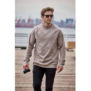 Men's Monashee fleece crew neck sweater in beige, worn by a man holding a camera, set against an outdoor background.